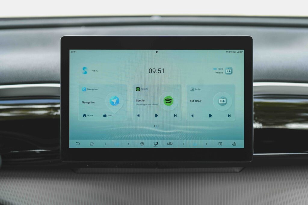 Close-up of the BYD Sealion 5 DM-i’s touchscreen display showing navigation, Spotify, and FM radio interface options on a clean, modern UI.