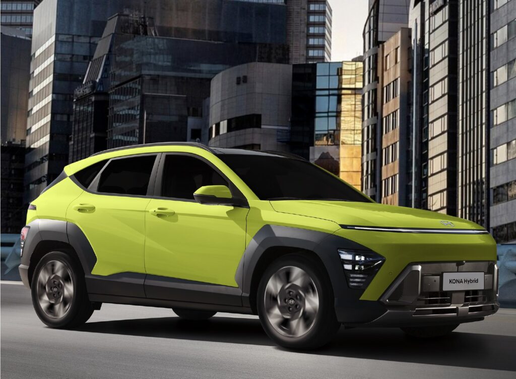 A vibrant lime-green Hyundai KONA Hybrid drives along an elevated city road surrounded by tall, modern buildings at dusk. The car’s futuristic design is highlighted by LED headlights, bold lines, and contrasting black wheel arches, capturing its dynamic urban character.