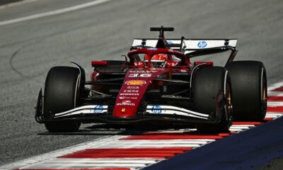 Ferrari Formula 1 driver Charles Leclerc powers through a corner at the Red Bull Ring during the 2025 Austrian Grand Prix, with his red SF-24 car riding the curb under bright track conditions.