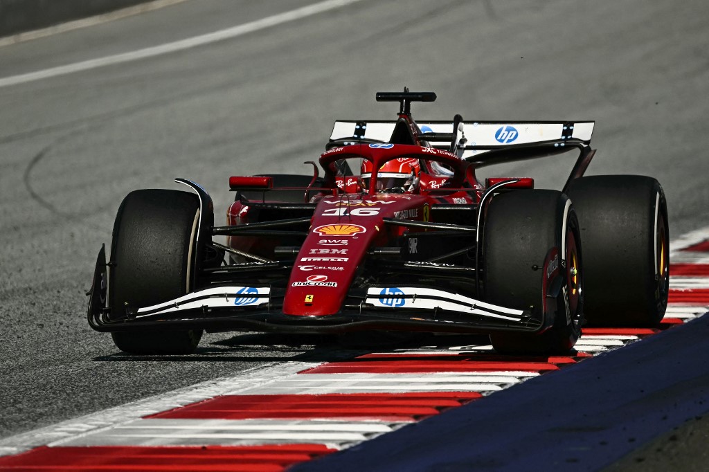 Ferrari Formula 1 driver Charles Leclerc powers through a corner at the Red Bull Ring during the 2025 Austrian Grand Prix, with his red SF-24 car riding the curb under bright track conditions.