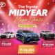 Three Toyota vehicles — Altis G GR-S CVT, Yaris Cross S HEV CVT, and Hilux 4x4 Conquest A/T — featured on a red and pink confetti-themed backdrop with text announcing "The Toyota Midyear Mega Deals" and benefits of up to ₱125,000.