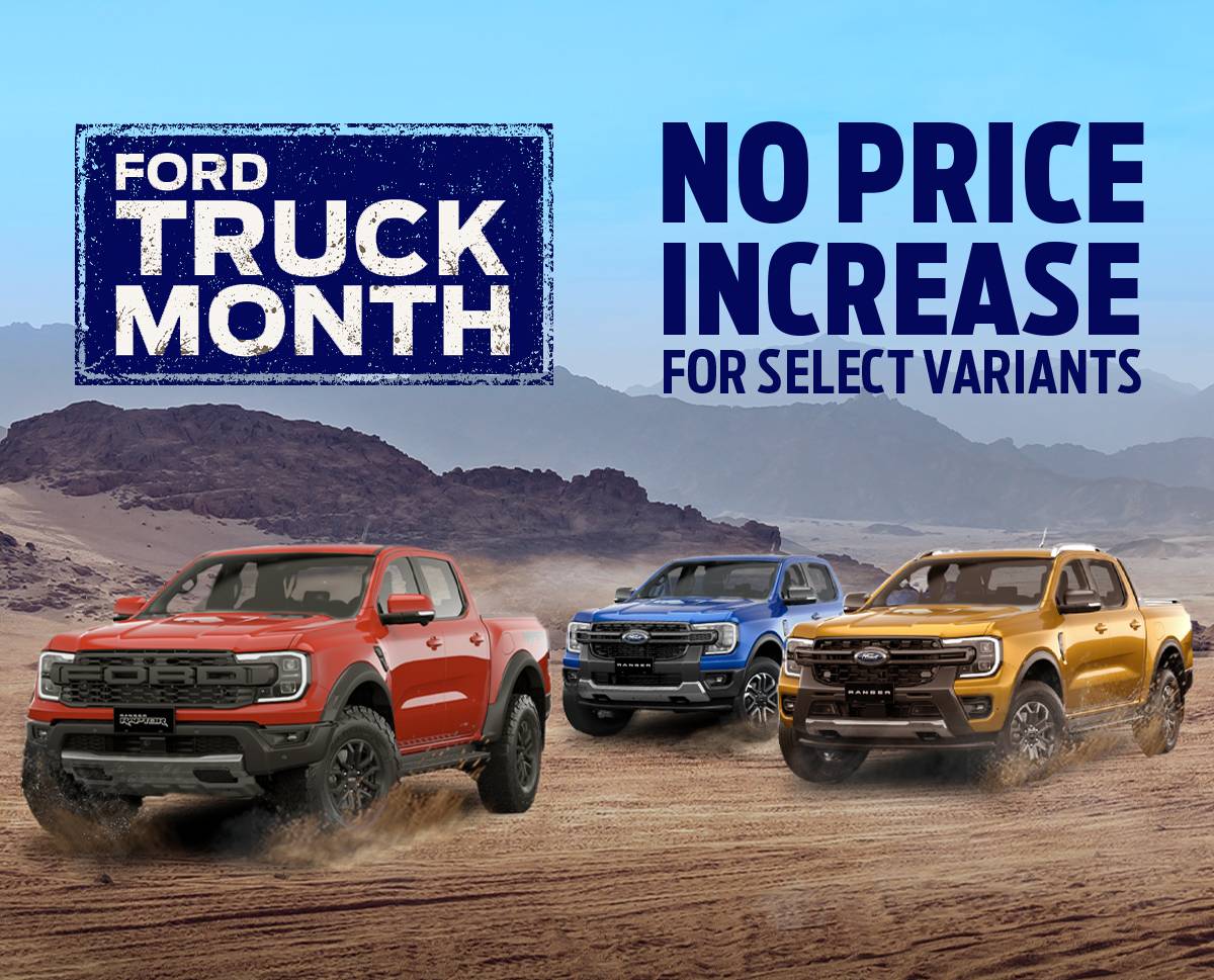 Three Ford Ranger pickup trucks — in red, blue, and orange — drive across a desert landscape beneath a bright blue sky. A large banner reads “Ford Truck Month” on the left, with the text “No Price Increase for Select Variants” on the right.
