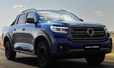 Blue GWM Cannon pickup truck driving on an open road under clear skies.