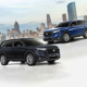 Two 2024 Honda CR-V VX Turbo CVT AWD units — one in Canyon River Blue Metallic and another in Meteoroid Gray Metallic — displayed with a modern city skyline in the background.