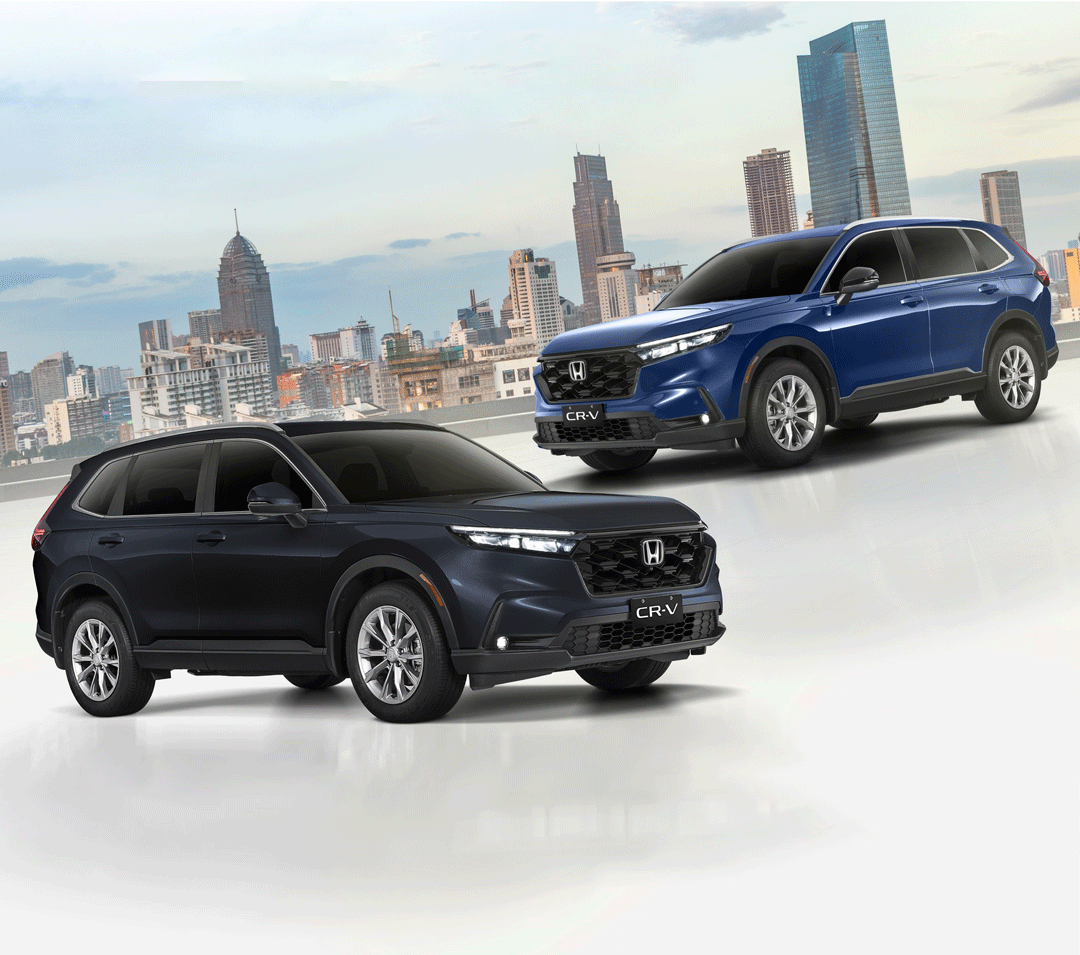 Two 2024 Honda CR-V VX Turbo CVT AWD units — one in Canyon River Blue Metallic and another in Meteoroid Gray Metallic — displayed with a modern city skyline in the background.