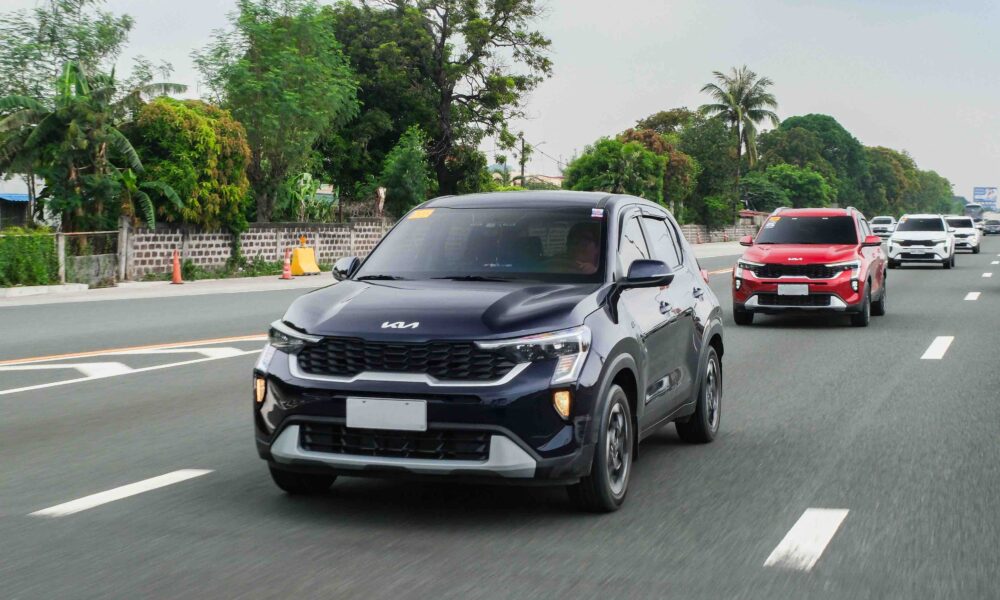 A convoy of Kia Sonet SUVs cruises along a highway, led by a black unit followed by red and white Sonets, during the Kia Sonet Pilipinas Club’s grand meet in Nuvali.
