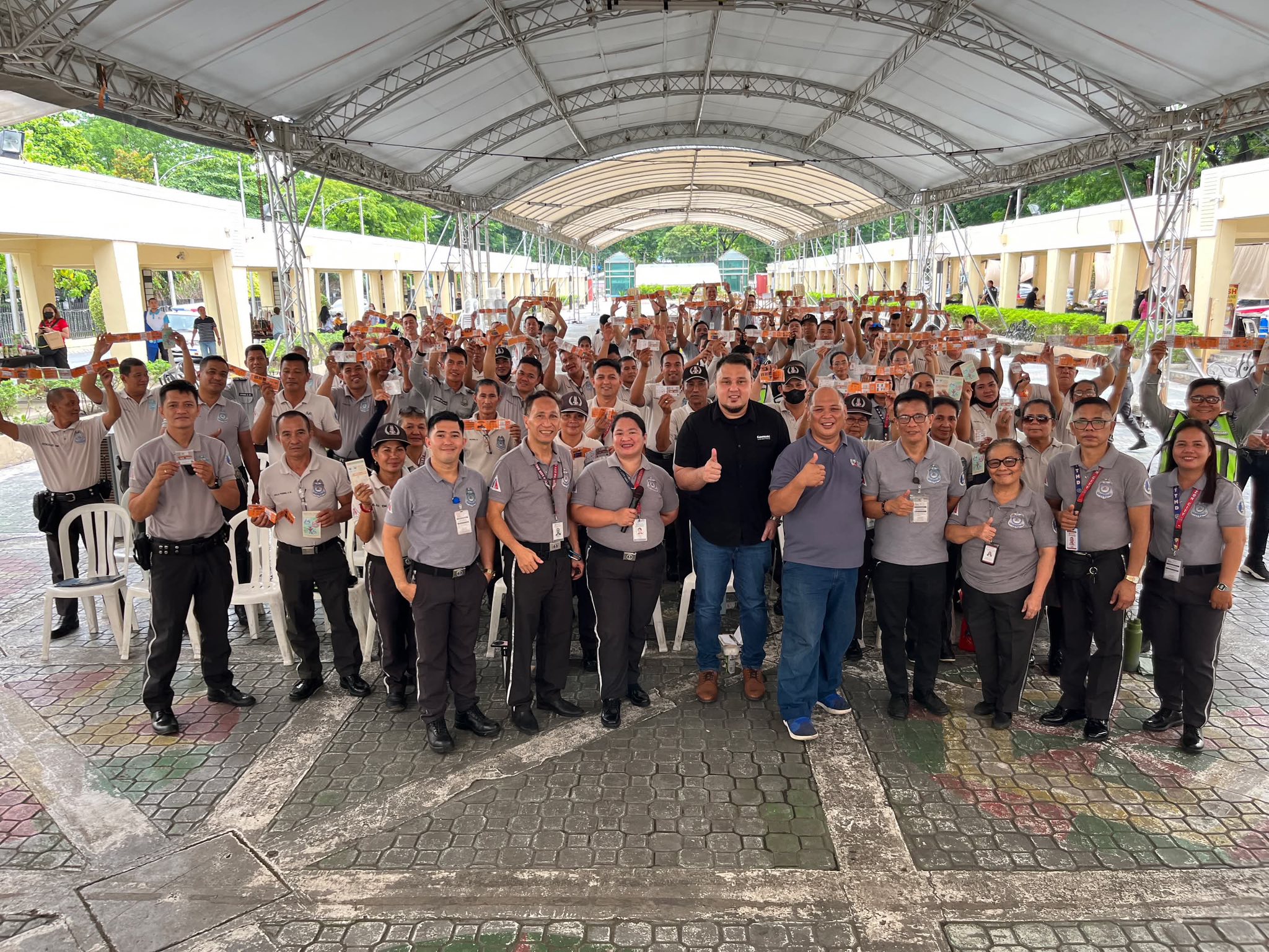 Group of Quezon City traffic enforcers and MDPPA representatives pose together during a road safety seminar under a covered outdoor venue.