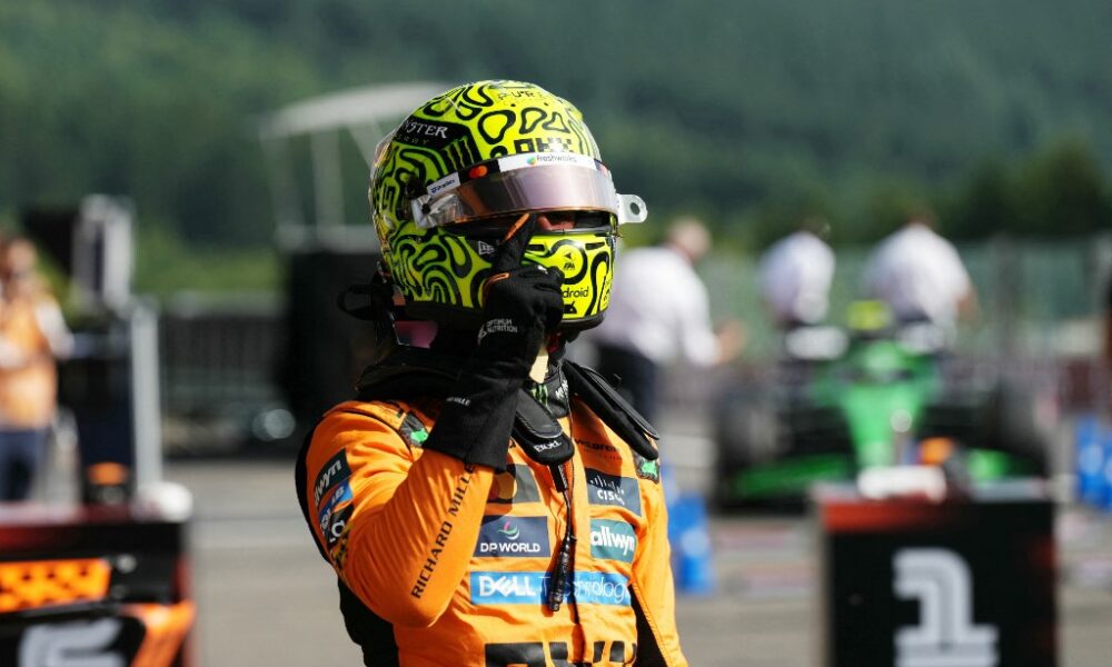 Lando Norris celebrates pole position in his McLaren race suit and helmet at Spa-Francorchamps