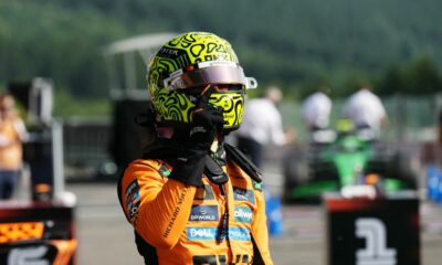 Lando Norris celebrates pole position in his McLaren race suit and helmet at Spa-Francorchamps