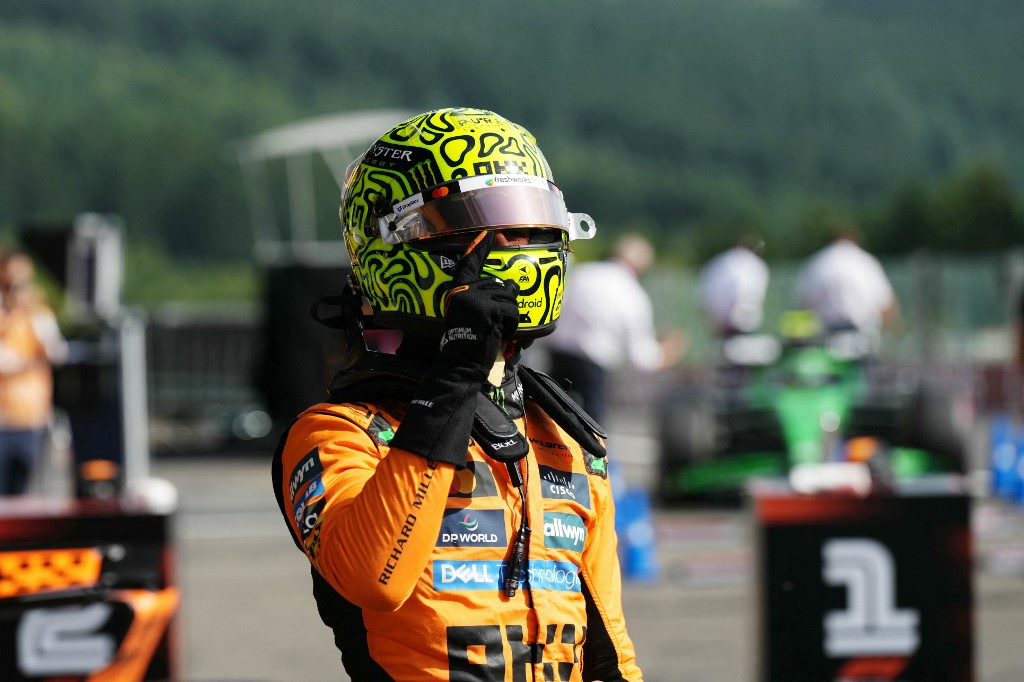 Lando Norris celebrates pole position in his McLaren race suit and helmet at Spa-Francorchamps