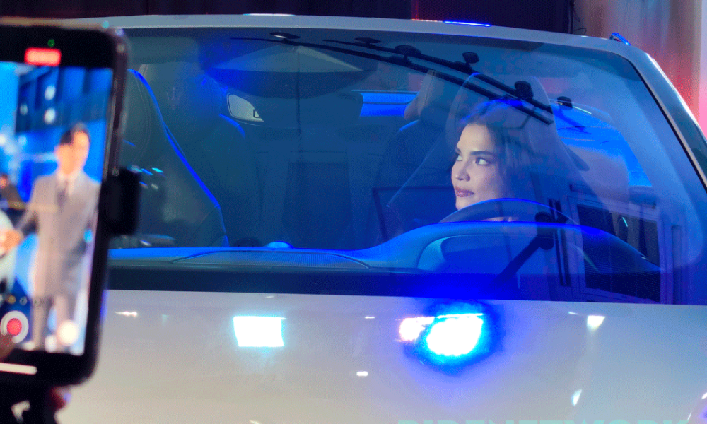 Actress Rhian Ramos sits inside the Maserati GranCabrio Folgore during its Philippine launch, illuminated by ambient blue lighting as an event livestream is captured on a nearby phone screen.