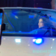 Actress Rhian Ramos sits inside the Maserati GranCabrio Folgore during its Philippine launch, illuminated by ambient blue lighting as an event livestream is captured on a nearby phone screen.