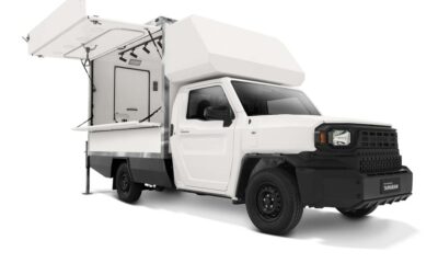 Side view of a white Toyota Tamaraw Mobile Store variant with its canopy doors open, revealing a compact interior fitted for mobile retail use.