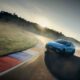 A Hyundai IONIQ 6 N powerslides around a racetrack corner at sunset, kicking up smoke and showcasing its performance handling.