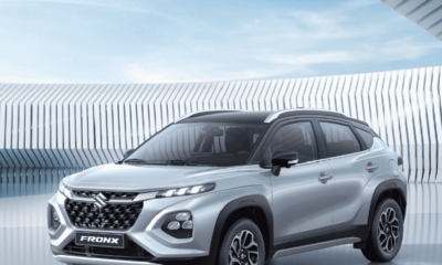 Silver Suzuki Fronx crossover parked in a modern architectural setting with geometric patterns in the background.