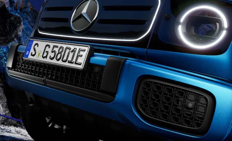 Close-up of the front grille and LED headlights of a blue Mercedes-Benz G 580 EQ, highlighting its modern electric design.