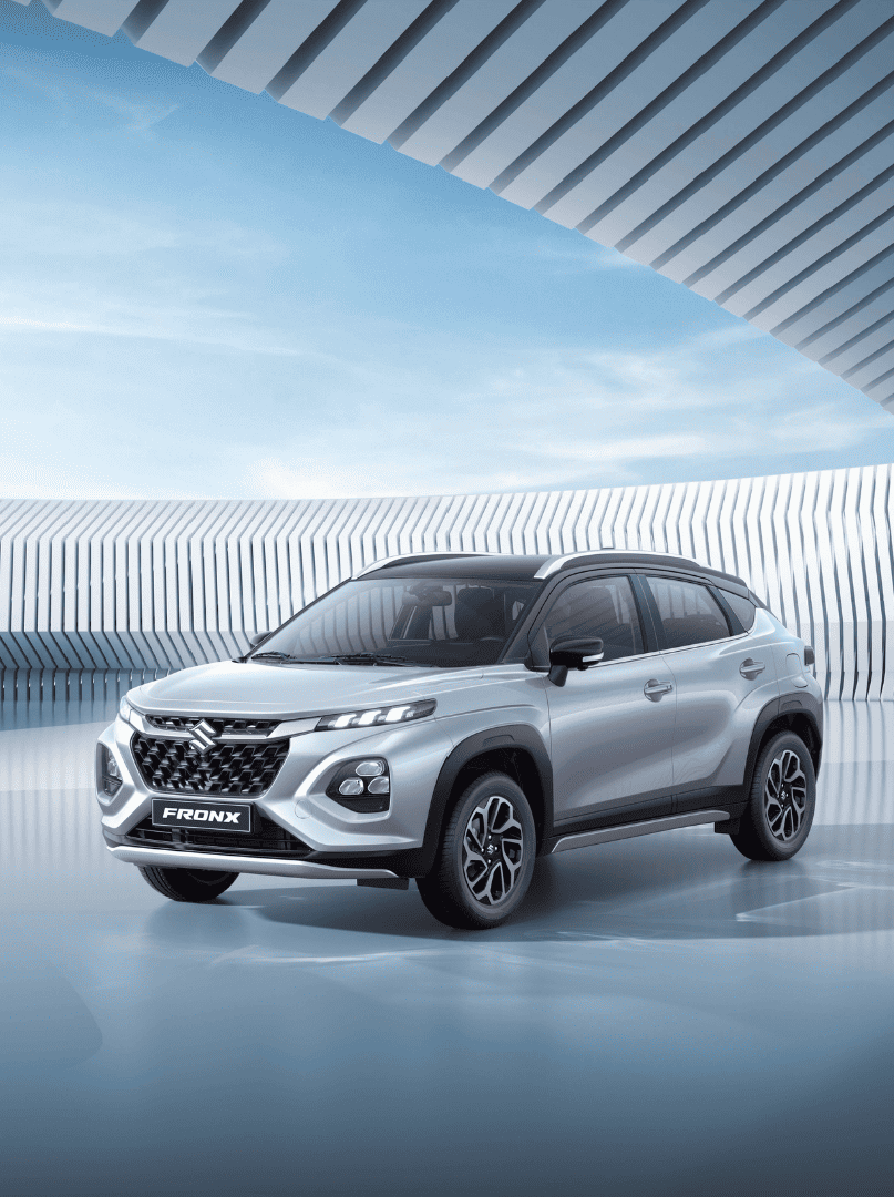 Silver Suzuki Fronx crossover parked in a modern architectural setting with geometric patterns in the background.