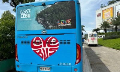 Back view of a blue Love Bus in Cebu with a heart-shaped logo and tourism branding.