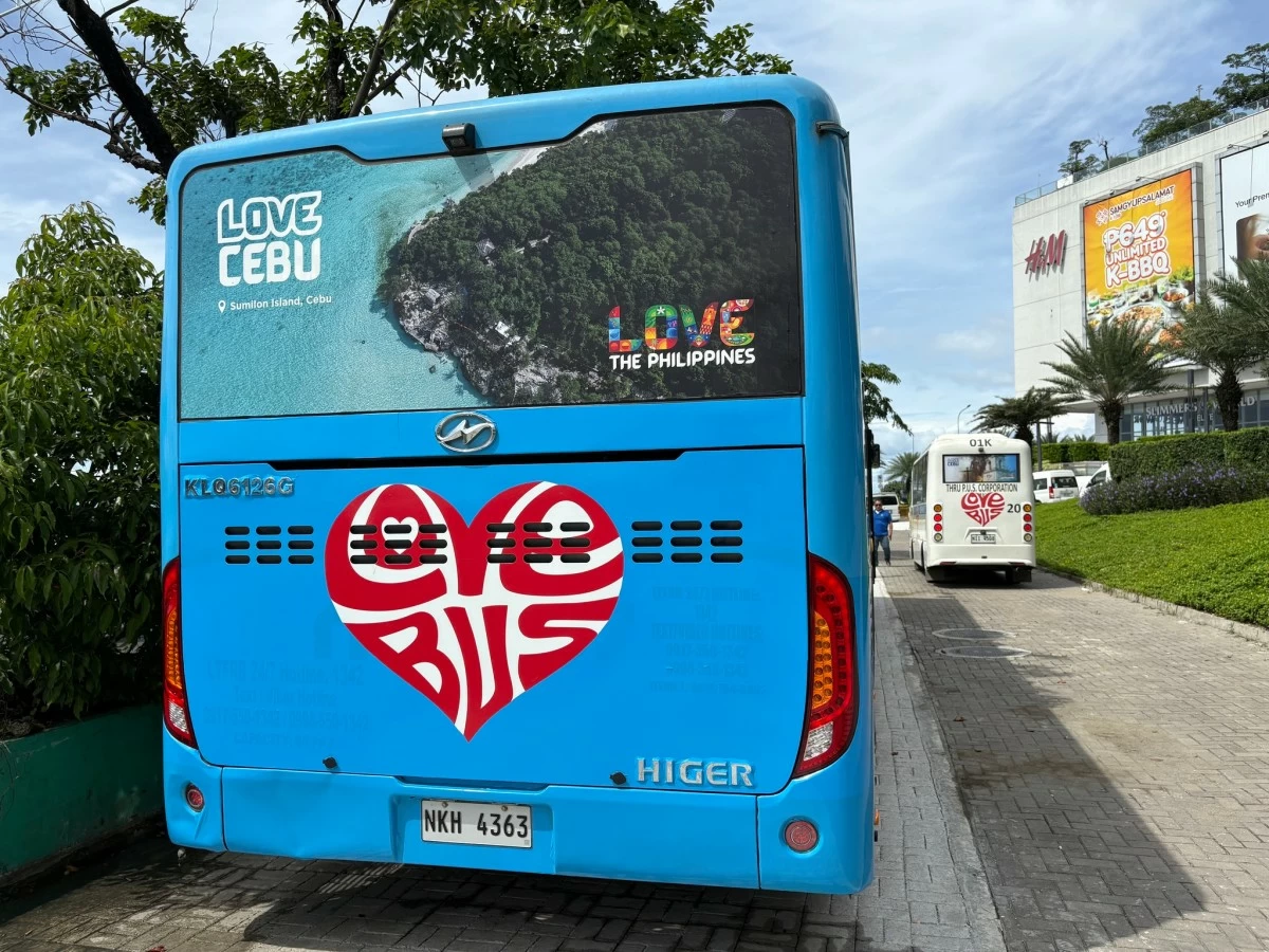 Back view of a blue Love Bus in Cebu with a heart-shaped logo and tourism branding.