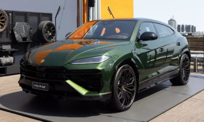 Green Lamborghini Urus SE SUV on display with black alloy wheels and orange interior accents.