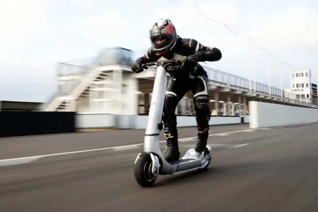 Rider in full racing gear riding a high-performance Bo Turbo electric scooter at high speed on a race track.