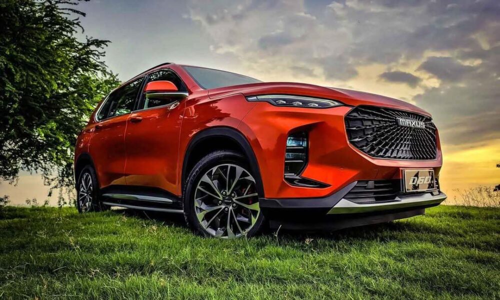 A striking red Maxus D60 SUV parked on a grassy field under a dramatic sunset sky.
