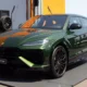 Green Lamborghini Urus SE SUV on display with black alloy wheels and orange interior accents.