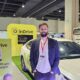 inDrive Regional Director Mark Tolley stands at the inDrive booth during the Philippine Commercial Vehicle Show 2025, with a white inDrive-branded car and promotional signage in the background.