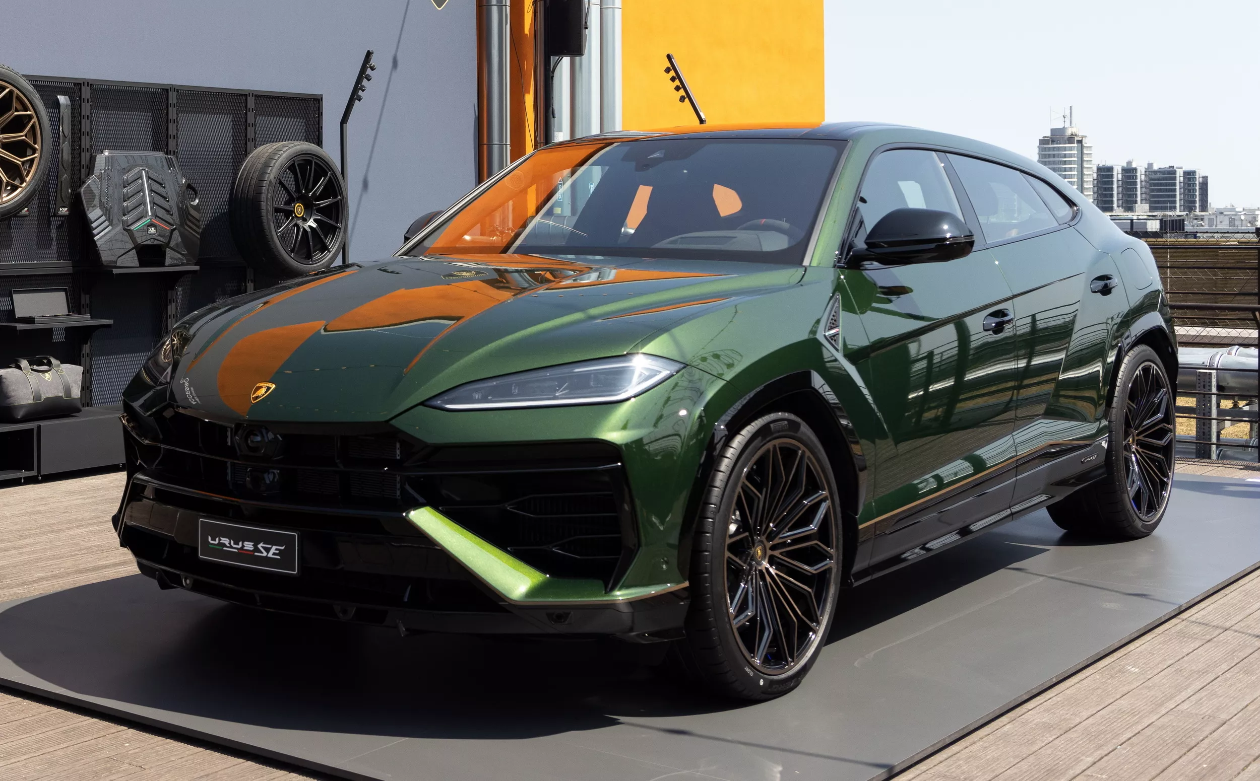 Green Lamborghini Urus SE SUV on display with black alloy wheels and orange interior accents.