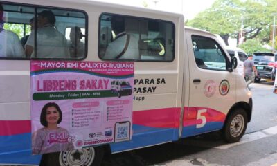 A white and pink Toyota Lite Ace community shuttle in Pasay City with a poster advertising “Libreng Sakay” (Free Ride) from Monday to Friday, 6 a.m. to 6 p.m., featuring Mayor Emi Calixto-Rubiano and the list of shuttle zones and stops.