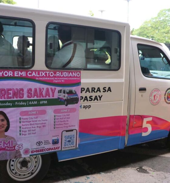 A white and pink Toyota Lite Ace community shuttle in Pasay City with a poster advertising “Libreng Sakay” (Free Ride) from Monday to Friday, 6 a.m. to 6 p.m., featuring Mayor Emi Calixto-Rubiano and the list of shuttle zones and stops.