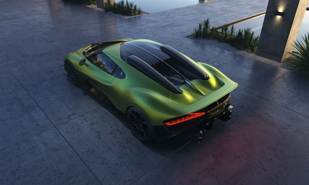 Rear three-quarter view of the Bugatti Brouillard in metallic green, parked by a modern concrete driveway beside a reflective water feature.
