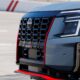 Close-up of the 2026 Nissan Armada NISMO front grille and headlight with red trim accents.