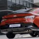 Rear view of the Hyundai Elantra N Line in red, showcasing its sporty bumper, dual exhausts, and bold taillight design.