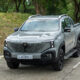 Front view of a gray Changan Nevo Hunter K50 range-extended electric pickup truck parked on a concrete road beside a grassy hillside.