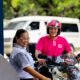 A smiling fuel station attendant assists a foodpanda rider on a motorcycle at a Caltex station.