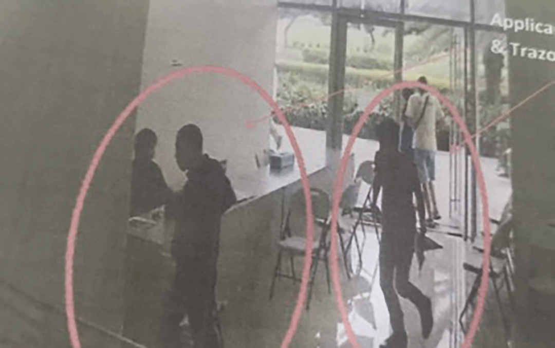 CCTV still image showing suspected fixers inside an office, highlighted with red circles for identification.