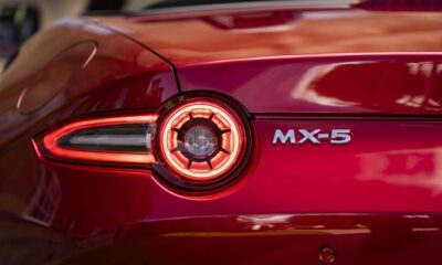 Close-up of the rear taillight and badge of a red Mazda MX-5 sports car.