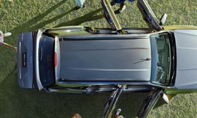 Aerial view of an Isuzu mu-X parked on grass with passengers opening the doors, ready for an outdoor trip.