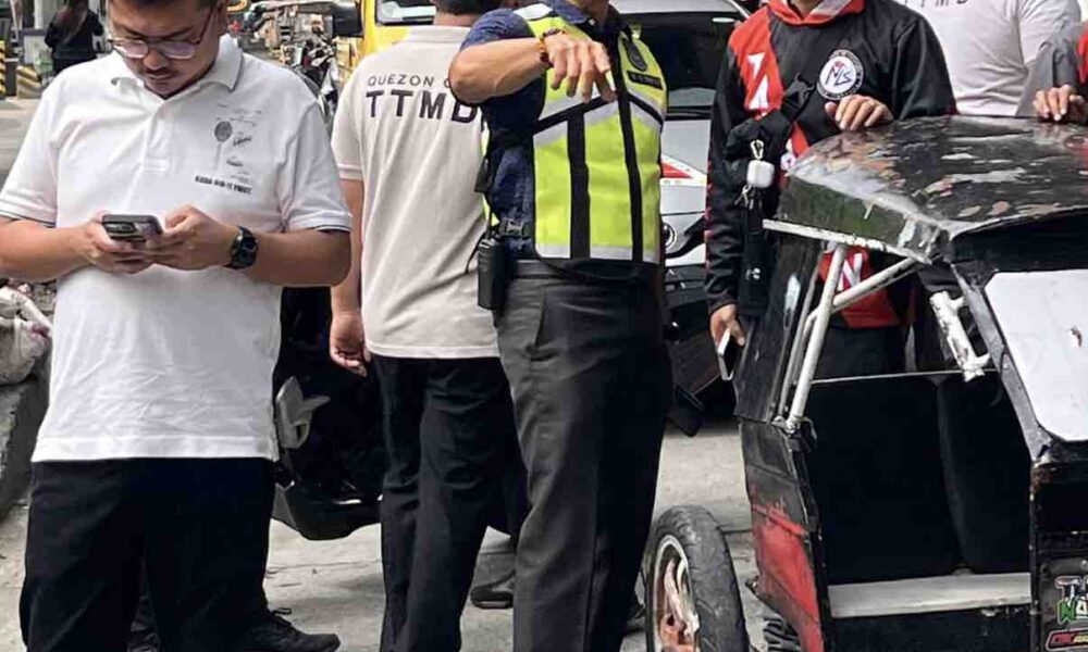 Quezon City traffic and safety officials inspect a damaged tricycle during a road clearing operation along G. Araneta Avenue.