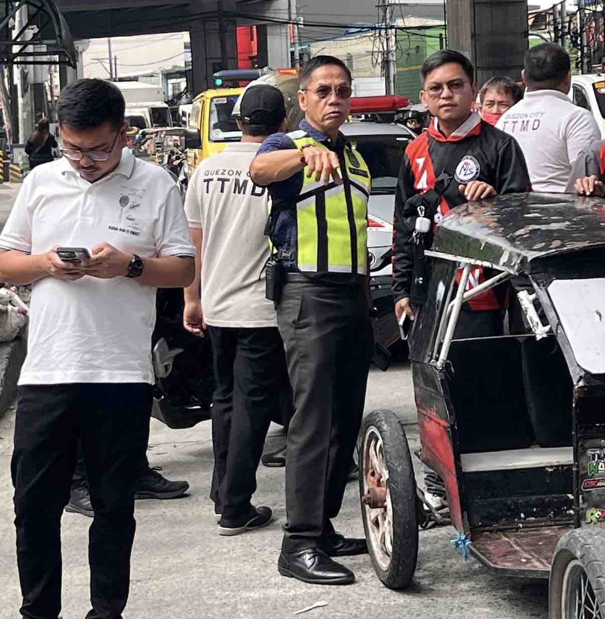 Quezon City traffic and safety officials inspect a damaged tricycle during a road clearing operation along G. Araneta Avenue.