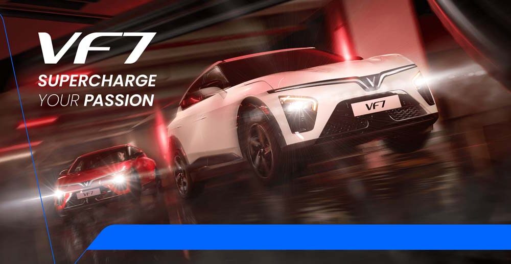 Two VinFast VF 7 electric SUVs—one in red, one in white—racing through a sleek, futuristic tunnel under dramatic red lighting, with motion blur emphasizing speed and power.