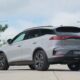 Rear view of the new BYD Tang DM-i plug-in hybrid SUV in silver, parked outdoors with trees and lamp posts in the background.