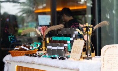 A display of Lynk & Co personalized giveaways, including passport holders and key holders, arranged on a decorated table at the Lynk Ups event.