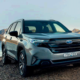 Front view of the 2026 Subaru Forester Hybrid parked by a lake with mountain scenery in the background.