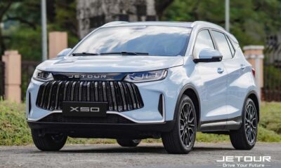 Front view of a white Jetour X50 SUV parked outdoors, showcasing its bold grille and modern design.