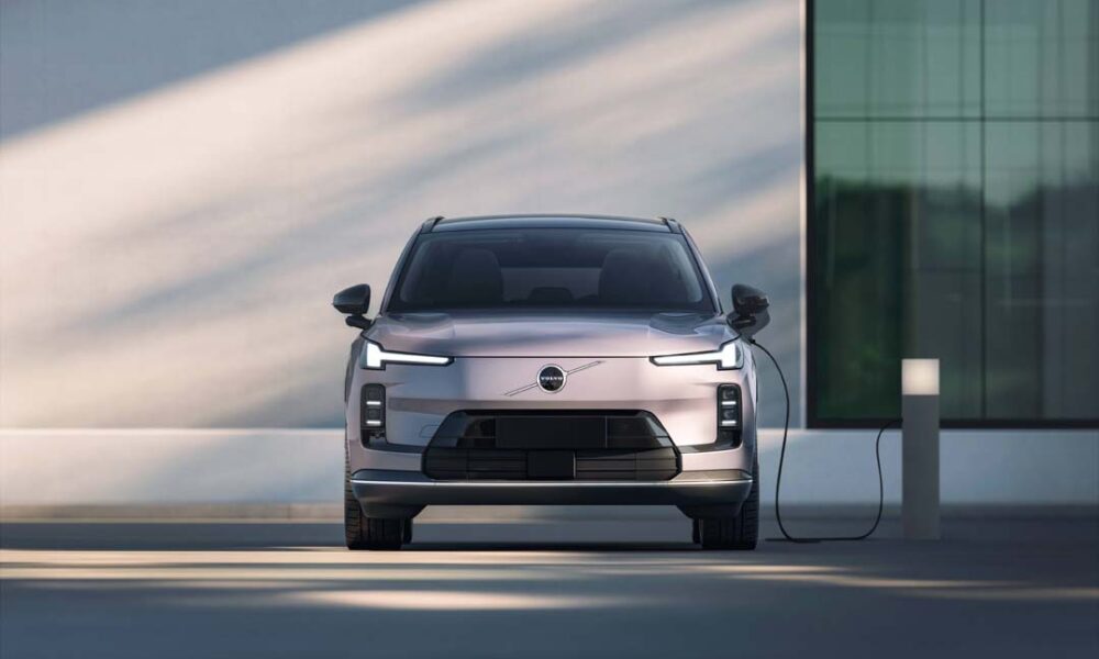 Front view of the Volvo XC70 plug-in hybrid charging at a modern station.