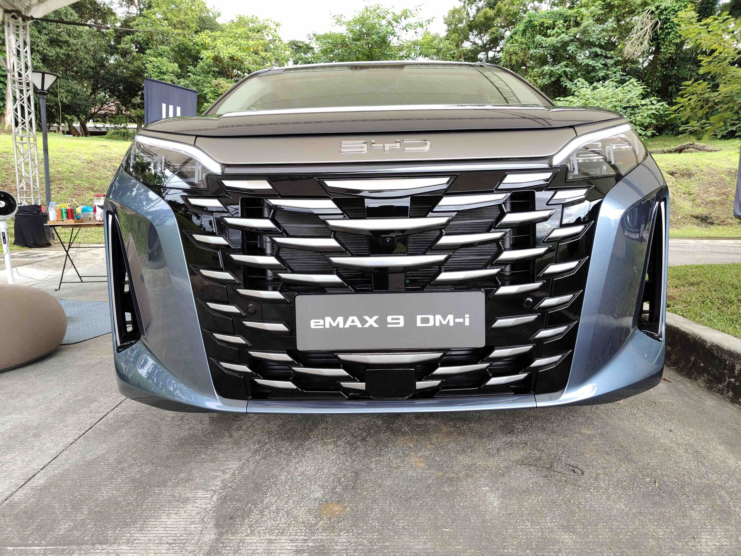 Front view of the BYD eMAX 9 DM-i showing its large chrome grille and sleek LED headlamps at Ayala Greenfield Golf & Leisure Club in Calamba, Laguna.