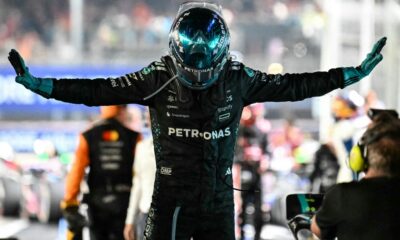Mercedes driver George Russell celebrates with arms outstretched after winning the Formula One Singapore Grand Prix under the lights of the Marina Bay Street Circuit.