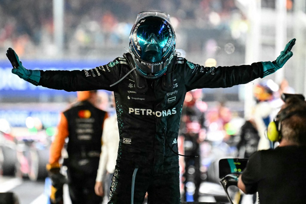 Mercedes driver George Russell celebrates with arms outstretched after winning the Formula One Singapore Grand Prix under the lights of the Marina Bay Street Circuit.